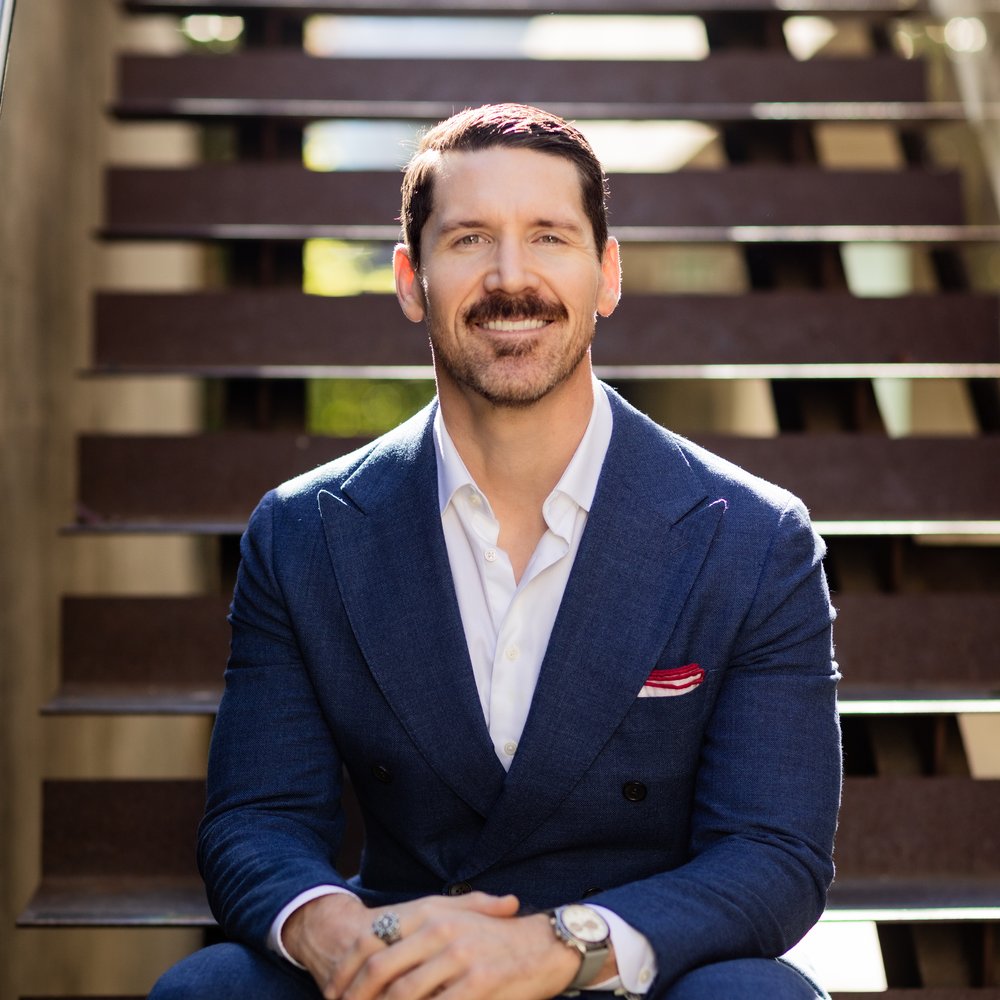 Adam Cato, San Diego mortgage broker and Certified Veterans Loan Specialist, smiling in a navy suit